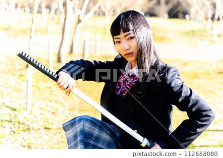 High school girl holding a sword High school girl holding a sword 112888080