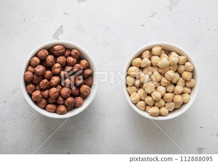 Peeled and blanched healthy hazelnut nuts on light background. 112888095