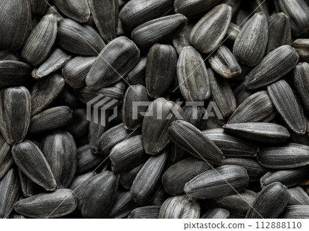 Raw dried black sunflower seeds top view macro background. Raw dried black sunflower seeds top view macro background. 112888110