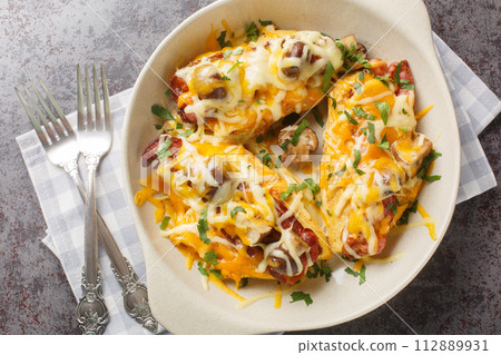 Alice Springs Chicken is a combination of chicken, bacon, cheese, mushrooms and honey mustard sauce closeup in the baking dish. Horizontal top view Alice Springs Chicken is a combination of chicken, bacon, cheese, mushrooms and honey mustard sauce closeup in the baking dish. Horizontal top view 112889931