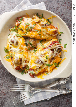 Tasty baked chicken breast in honey mustard sauce, topped with mushrooms, bacon, and a pile of cheese closeup in the baking dish. Vertical top view Tasty baked chicken breast in honey mustard sauce, topped with mushrooms, bacon, and a pile of cheese closeup in the baking dish. Vertical top view 112889934