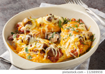 Chicken breasts are topped with a honey mustard sauce, bacon, cheese, and mushrooms closeup in the baking dish. Horizontal Chicken breasts are topped with a honey mustard sauce, bacon, cheese, and mushrooms closeup in the baking dish. Horizontal 112889938