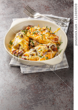 Alice Springs Chicken is a yummy cheesy, bacon and mushroom, delicious hot mess closeup in the baking dish. Vertical Alice Springs Chicken is a yummy cheesy, bacon and mushroom, delicious hot mess closeup in the baking dish. Vertical 112889939