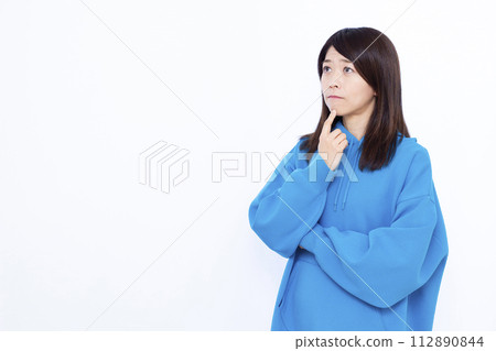 A woman wearing a blue hoodie who is seriously worried A woman wearing a blue hoodie who is seriously worried 112890844