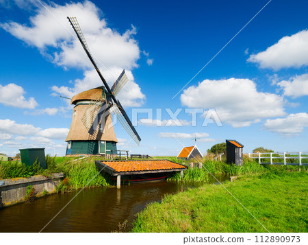 An old mill in the Netherlands. Historical building. A mill near a canal. An old mill in the Netherlands. Historical building. A mill near a canal. 112890973