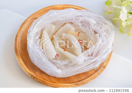 Fresh onions pickled in white soup stock made in a plastic bag 112891598