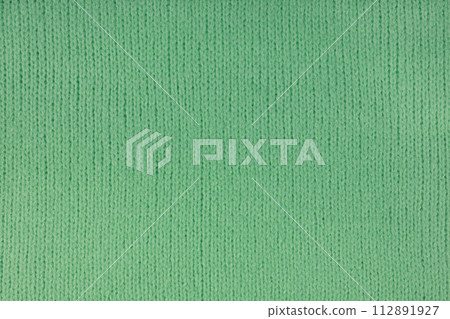 Green knitted woolen jersey fabric, sweater, pullover texture, abstract background Green knitted woolen jersey fabric, sweater, pullover texture, abstract background 112891927