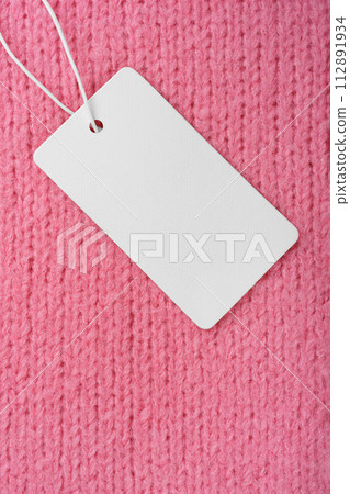 Template of blank clothing label, price tag on pink knitted sweater background Template of blank clothing label, price tag on pink knitted sweater background 112891934
