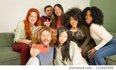 Multi-ethnic friends taking a selfie at home Multi-ethnic friends taking a selfie at home 112892089