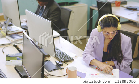 Concentrated woman working in paperwork in a coworking 112892096
