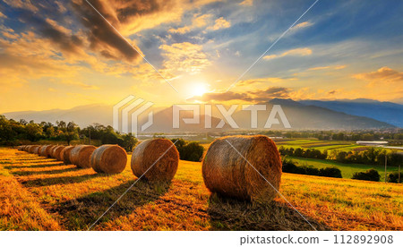Row of Hay Bales on a Golden Beautiful Landscape at Sunrise - Generative Ai 112892908