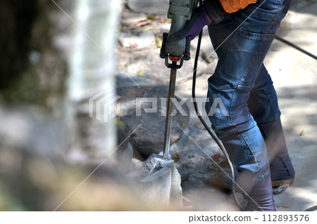 Chiseling work - crushing concrete blocks with a hammer drill Chiseling work - crushing concrete blocks with a hammer drill 112893576