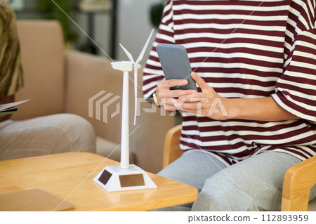 Cropped image of woman photographing model of wind turbine Cropped image of woman photographing model of wind turbine 112893959