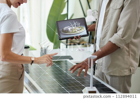 Engineer and investor discussing project of facility running on solar and wind power 112894011