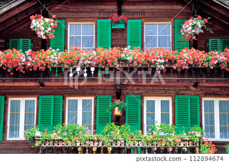 Flowers shining in the windows of a building 112894674