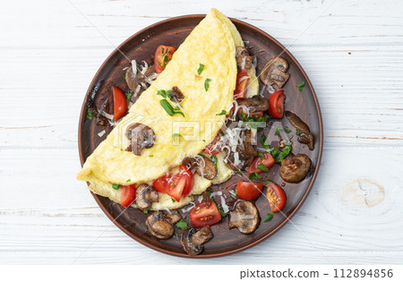 Omelette stuffed with mushrooms , tomatoes and parsley Omelette stuffed with mushrooms , tomatoes and parsley 112894856