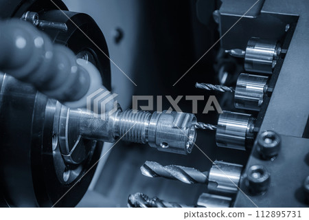 The  multi tasking CNC lathe machine swiss type tapping the brass fitting parts. 112895731
