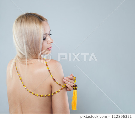 Amber long necklace sautoir on female back on white background Amber long necklace sautoir on female back on white background 112896351