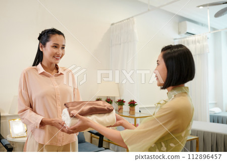 Wax salon worker giving client fresh towels 112896457