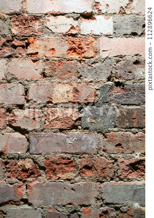 A Crumbling Indoor Vintage Brick Wall with Red Bricks 112896624
