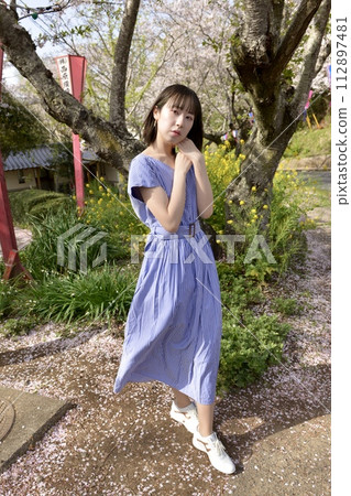 年輕女子在櫻花盛開的公園裡擺姿勢 112897481