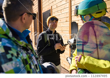 Three Friends is Chatting Before Snowboarding 112897495
