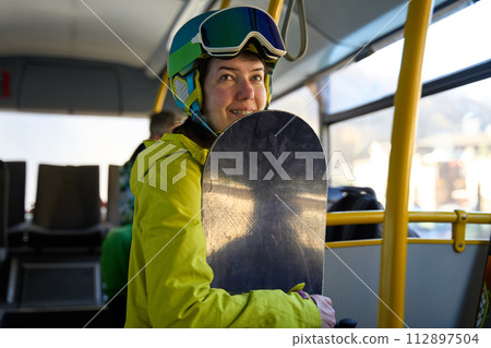 Snowboarder Smiling on Resort Shuttle Bus Snowboarder Smiling on Resort Shuttle Bus 112897504