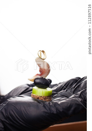 Canape, hands in black gloves hold a beautiful canape on a cap. Catering, snacking, food. Studio photo. Canape, hands in black gloves hold a beautiful canape on a cap. Catering, snacking, food. Studio photo. 112897516