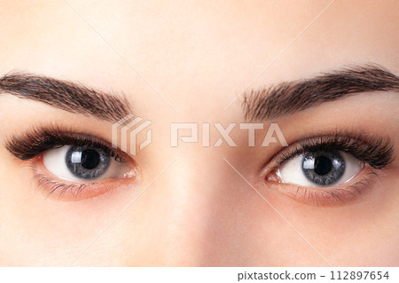 Eyelash removal procedure close up. Beautiful Woman with long lashes in a beauty salon. Eyelash extension. Eyelash removal procedure close up. Beautiful Woman with long lashes in a beauty salon. Eyelash extension. 112897654