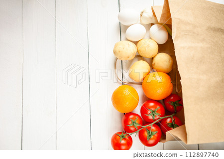Paper bag on a wooden background, vegetables from the store 112897740