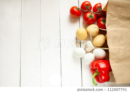 Paper bag on a wooden background, vegetables from the store 112897741