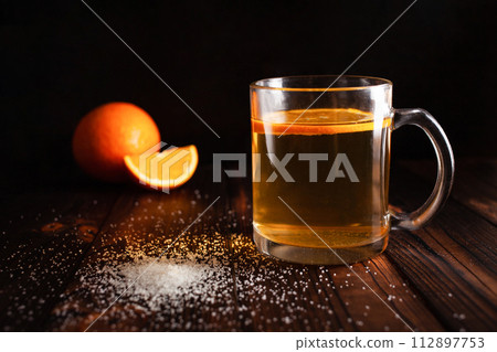 Tea with orange, sprinkled sugar, sliced orange, wooden brown backgroun Tea with orange, sprinkled sugar, sliced orange, wooden brown backgroun 112897753