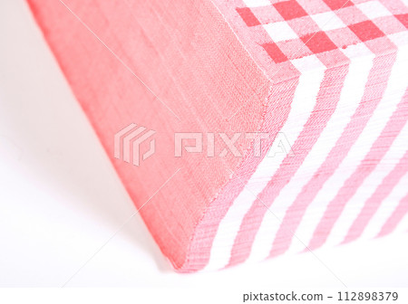 Closeup of a stack of red checked or checkered paper napkins isolated Closeup of a stack of red checked or checkered paper napkins isolated 112898379