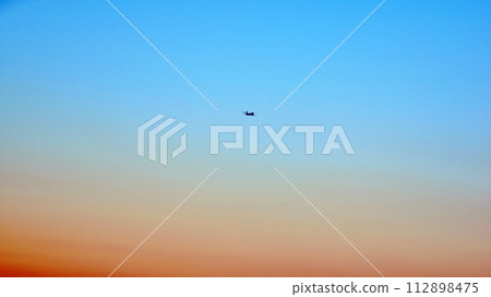 飛機在日落前在天空中起飛 112898475