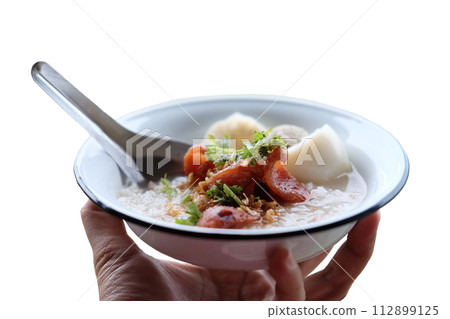Woman hand holding rice porridge with pork and Fried Chinese sausage in white bowl isolated on white background Woman hand holding rice porridge with pork and Fried Chinese sausage in white bowl isolated on white background 112899125