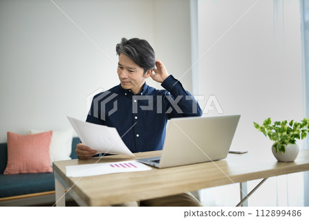 中年男子在客廳進行遠距辦公 112899486