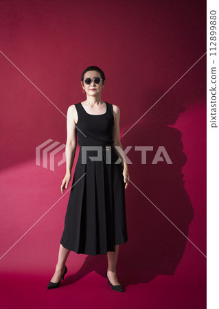 A woman in a black dress 112899880