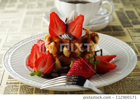 Belgian waffles and strawberries with chocolate sauce and coffee 112900171