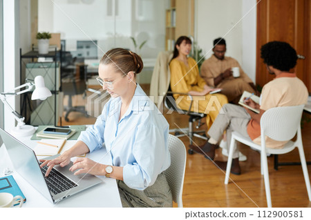 Manager working on pitch deck when team discussing mobile app update 112900581