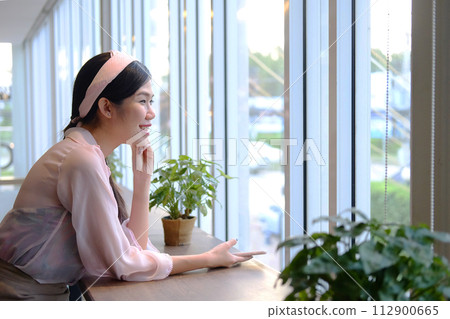 Beautiful Asian businesswoman is smiling and relaxing in cafe 112900665