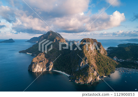 Aerial view of beach, sea and mountain on sunset. El Nido, Palawan. Tropical landscape hill, mountains rocks with rainforest and azure water of lagoon. Aerial view of beach, sea and mountain on sunset. El Nido, Palawan. Tropical landscape hill, mountains rocks with rainforest and azure water of lagoon. 112900853