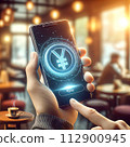a hand holds a phone with a floating 3D yen coin hologram 112900945