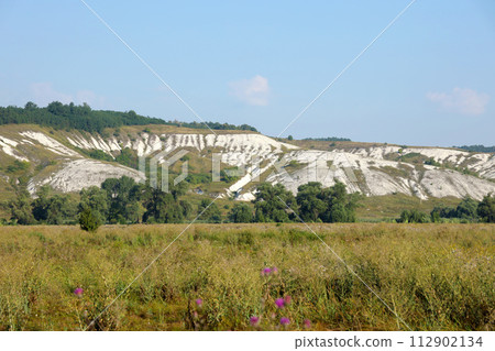 Ancient multimillion chalk mountains on the steppe surface of earth. White chalk mountains in the Dvurechansky park reserve in Ukraine Ancient multimillion chalk mountains on the steppe surface of earth. White chalk mountains in the Dvurechansky park reserve in Ukraine 112902134