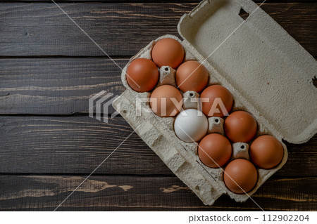 Fresh chicken eggs in a paper tray on the table, selective focus Fresh chicken eggs in a paper tray on the table, selective focus 112902204