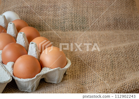 Fresh chicken eggs in a paper tray on the table, selective focus Fresh chicken eggs in a paper tray on the table, selective focus 112902243