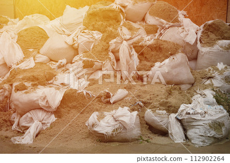 Texture of broken barricade wall made of white sandbags for war purposes. Defense concept background bags to strengthen the defensive structure during the battle. 112902264