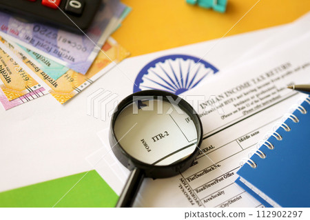 Indian income tax return blank form with pen and indian rupees bills on indian country flag close up. Annual tax report concept 112902297