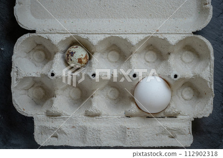 Fresh quail and chicken eggs in a paper tray, top view selective focus Fresh quail and chicken eggs in a paper tray, top view selective focus 112902318
