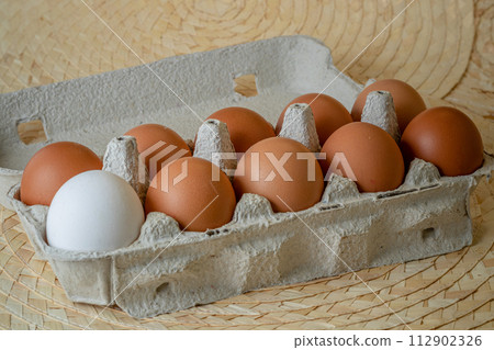 Fresh chicken eggs in a paper tray on the table, selective focus Fresh chicken eggs in a paper tray on the table, selective focus 112902326