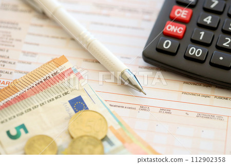 Filling italian tax form process with pen, calculator and euro money bills close up. Tax paying period and deadline 112902358